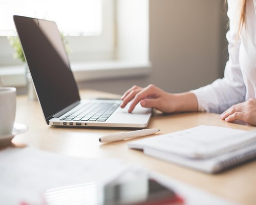 Woman stretching arms at office desk near window